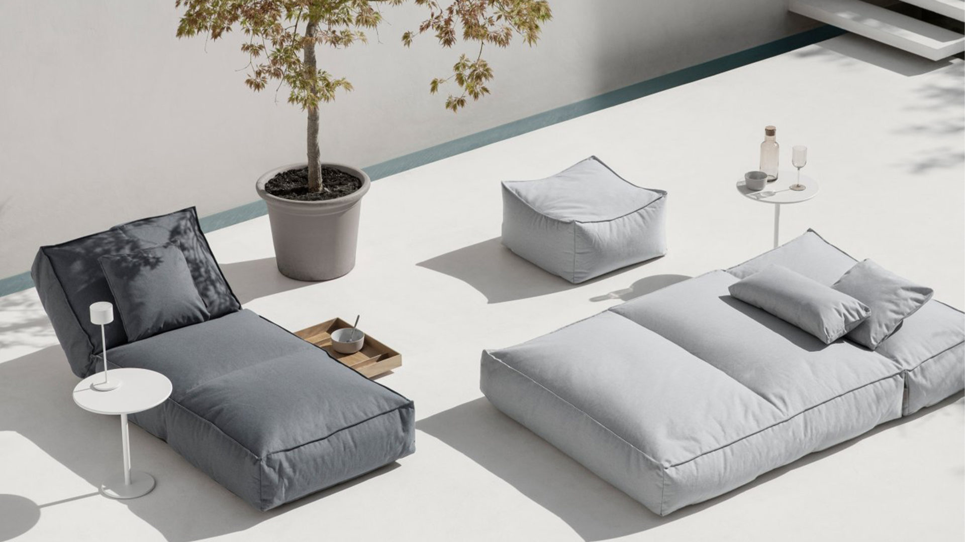 blomus loungemöbel stay in grau auf einer weißen terrasse im minimalismus stil