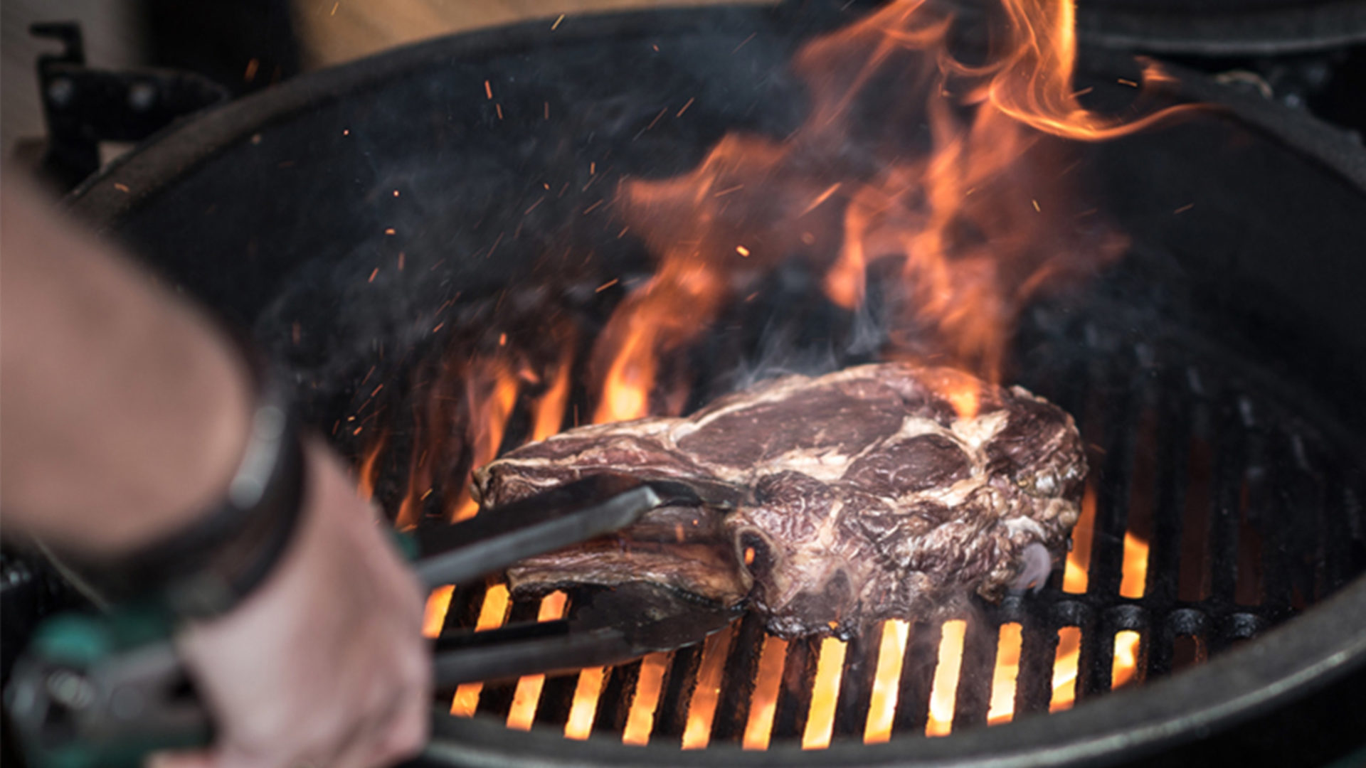 big green egg holzkohlegrill mit offener flamme und gegrilltem steak