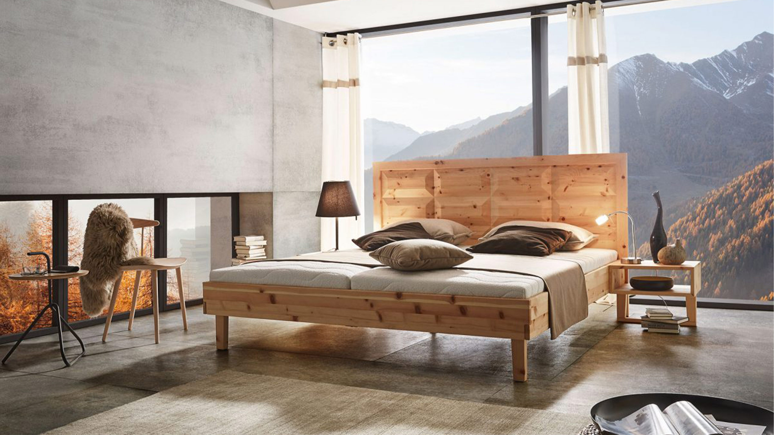 ada tyrol holzbett vor alpen kulisse