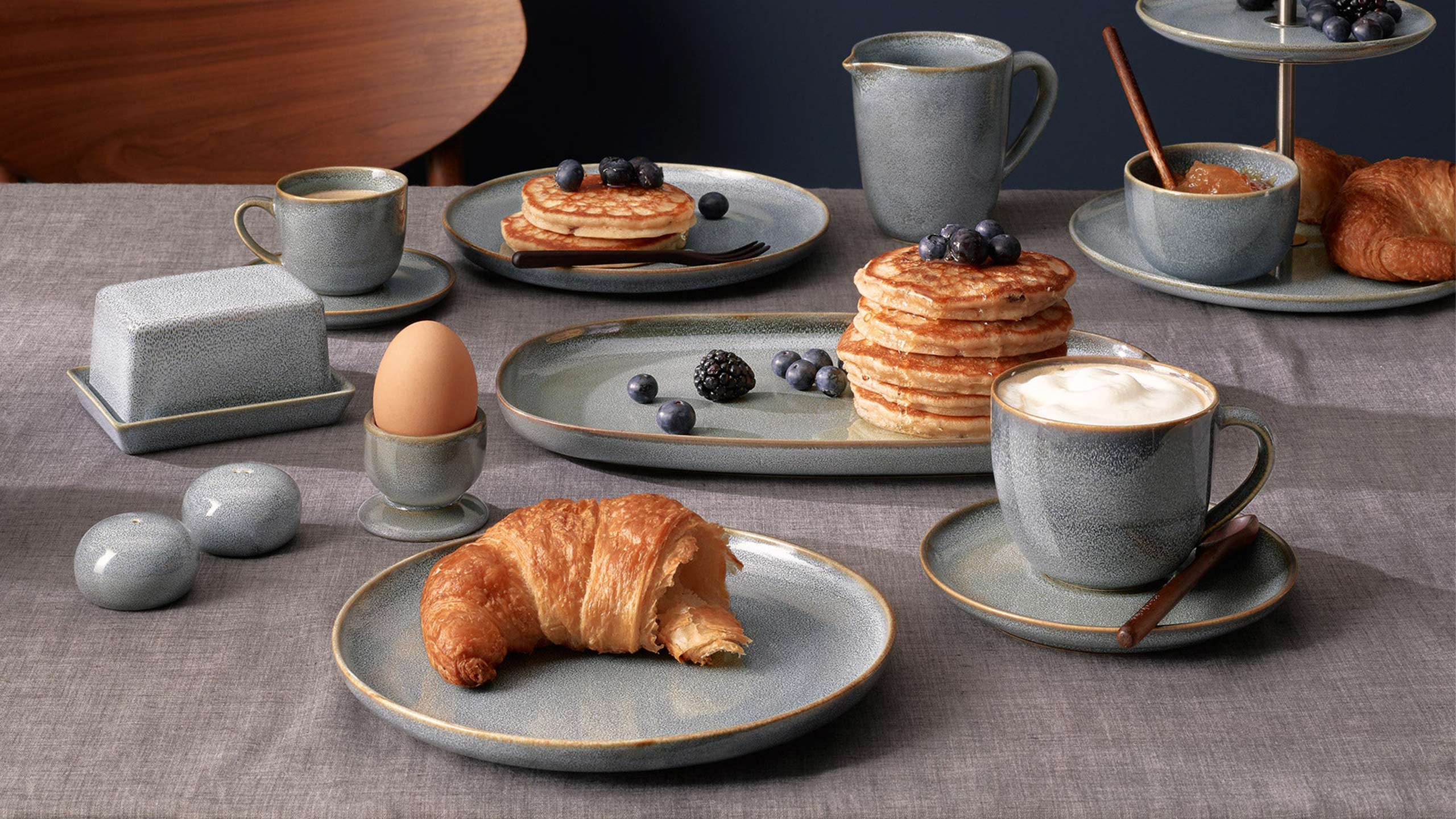 asa saisons denim geschirr auf einem gedeckten frühstückstisch mit croissant, cappuccino und pancakes
