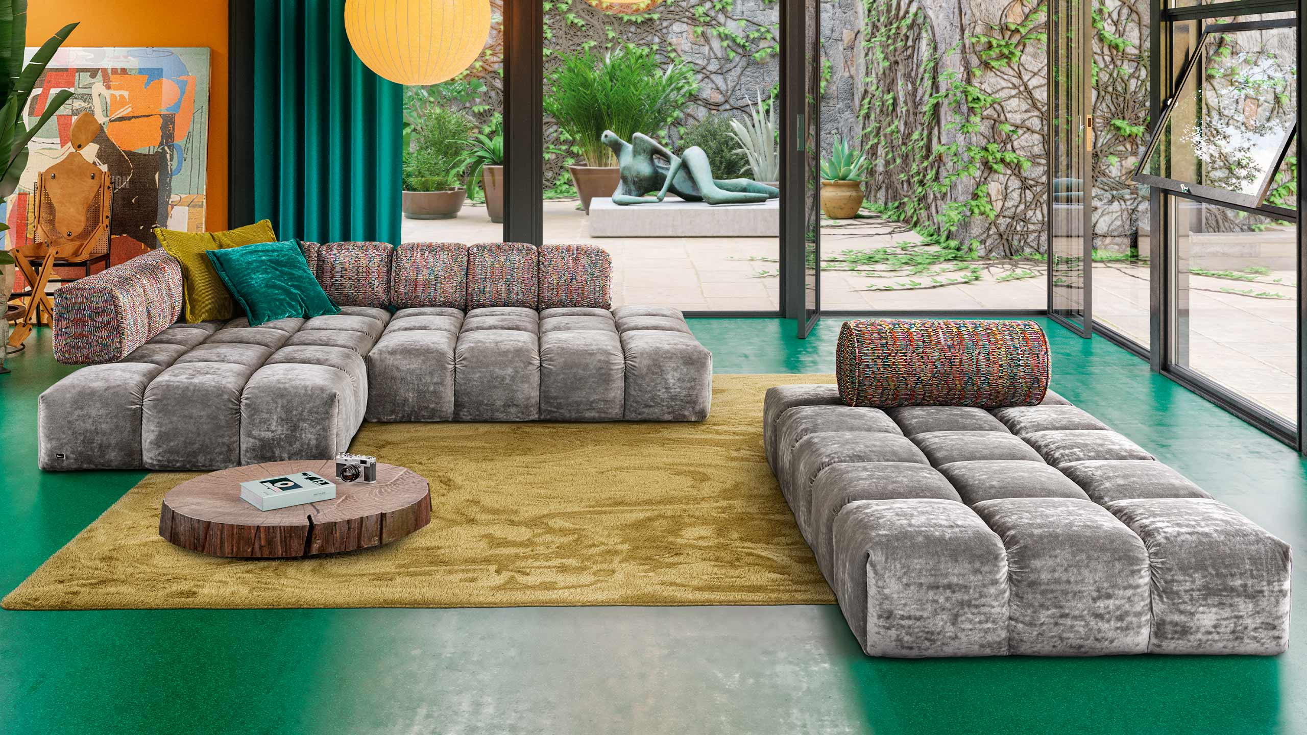 bretz edgy sofa in grau in einem modernen wohnzimmer vor einem bodentiefen fenster