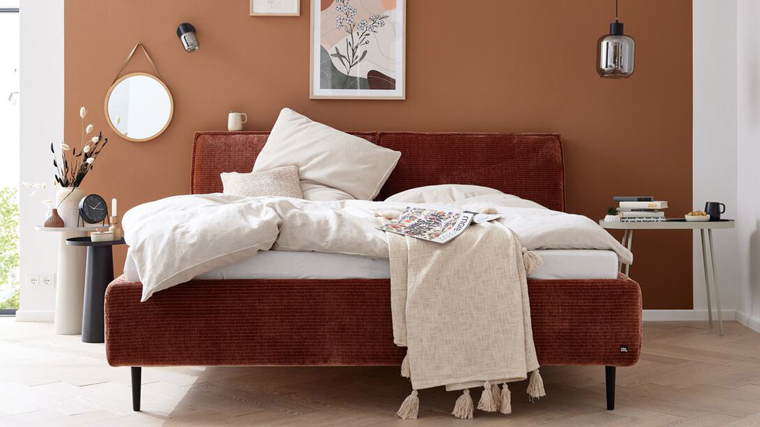 interliving 1417 bett aus cord in braun vor einer braunen wand mit bildern