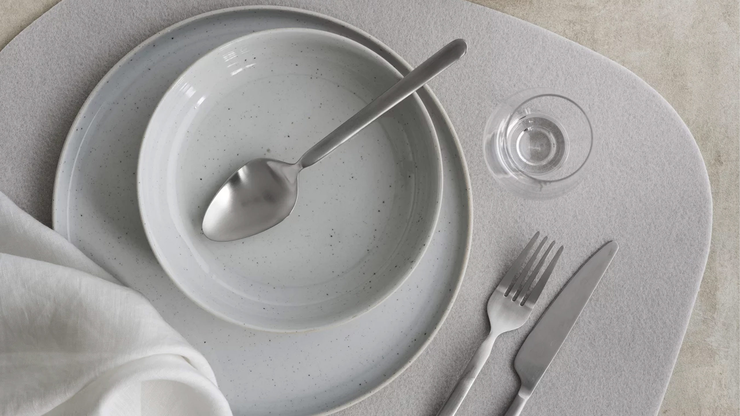 blomus sabo geschirr in grau auf einem grauen tischset von oben