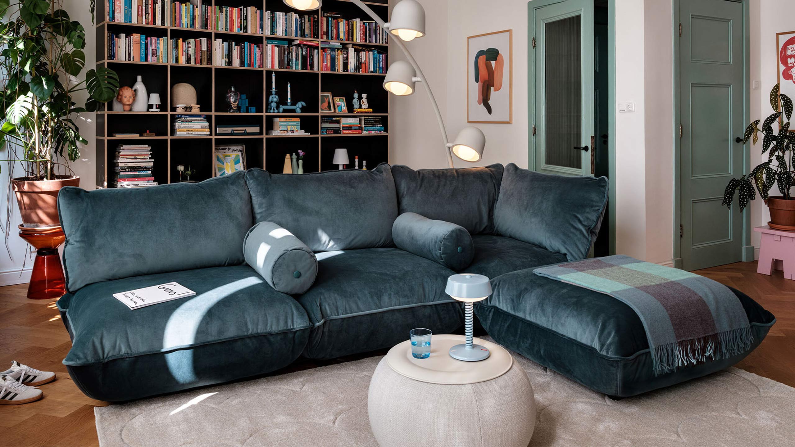 fatboy sumo sofa in petrol blau vor einem vollen regal im wohnzimmer