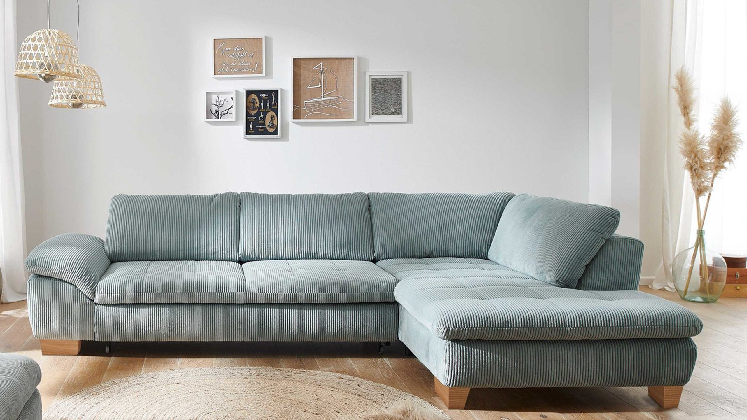 megapol vs mp1028 cordsofa in aqua blau vor einer wohnzimmerwand mit fünf bilderrahmen
