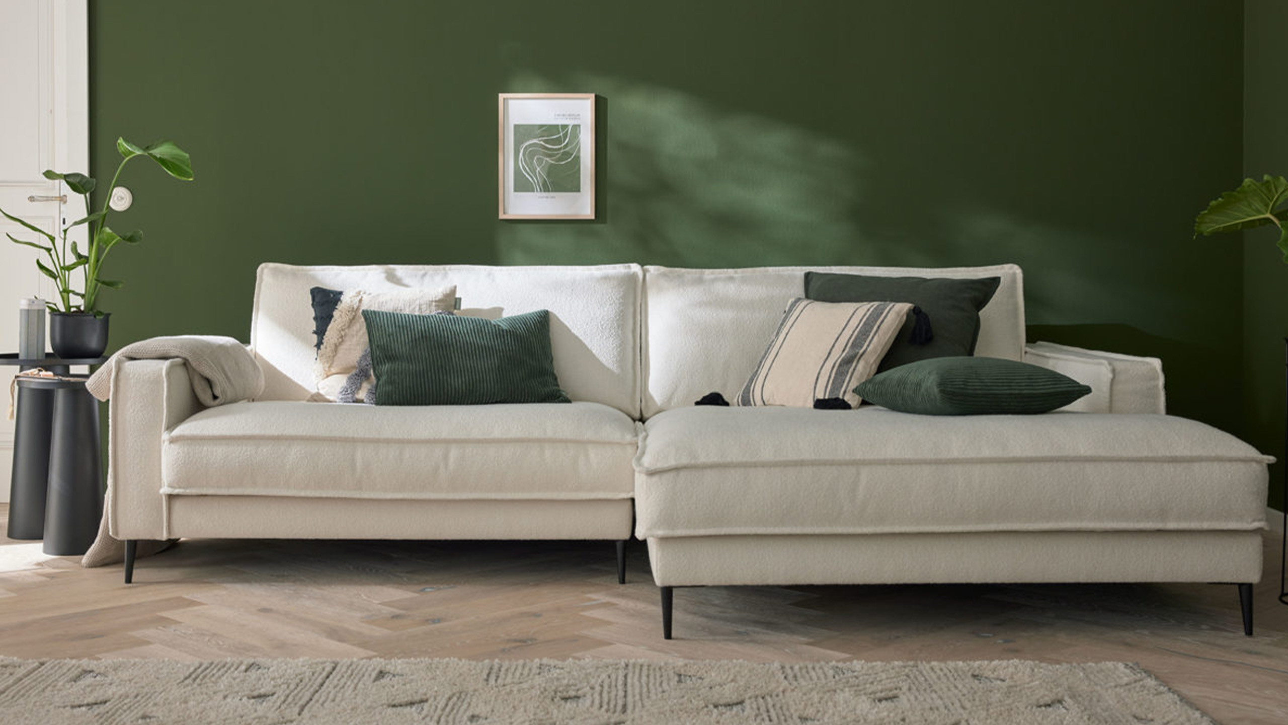 roomio sofa no 4102 in creme vor einer grünen wand