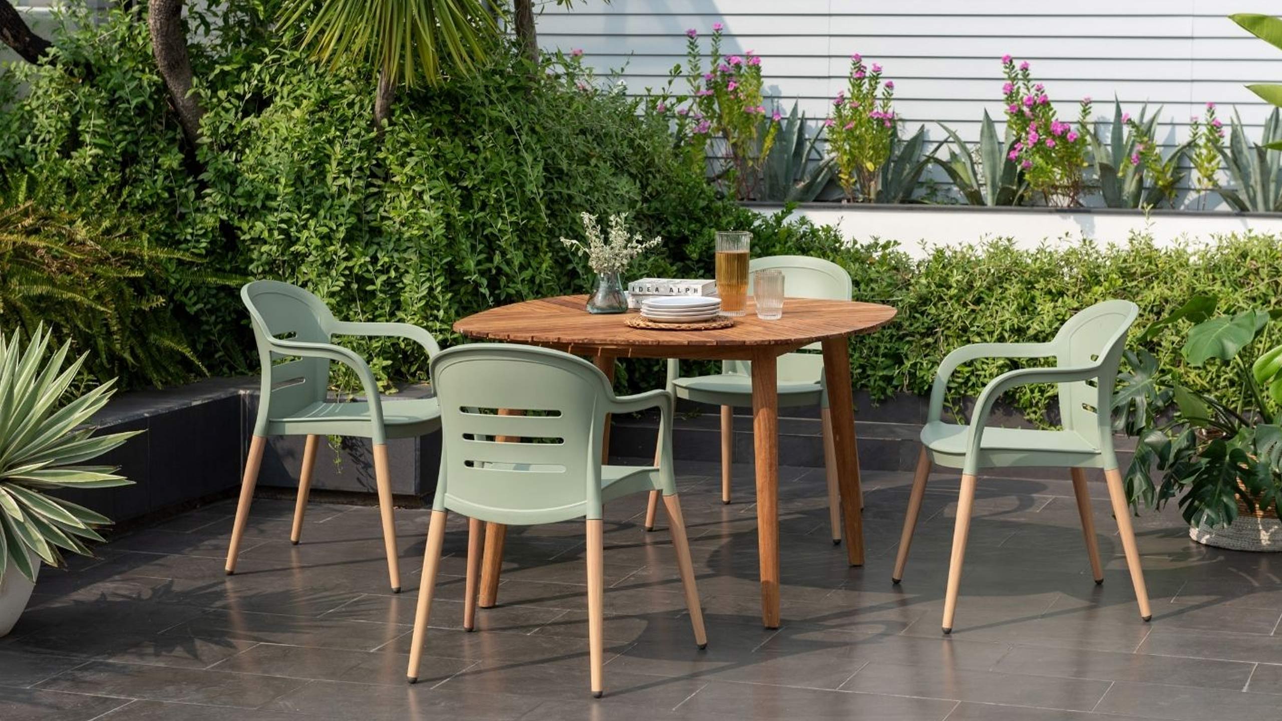 moebel-magazin-scancom-lifetsylegarden-onyx-outdoor-gruen vier scancom onyx outdoorstühle in grün an einem teakholztisch draußen