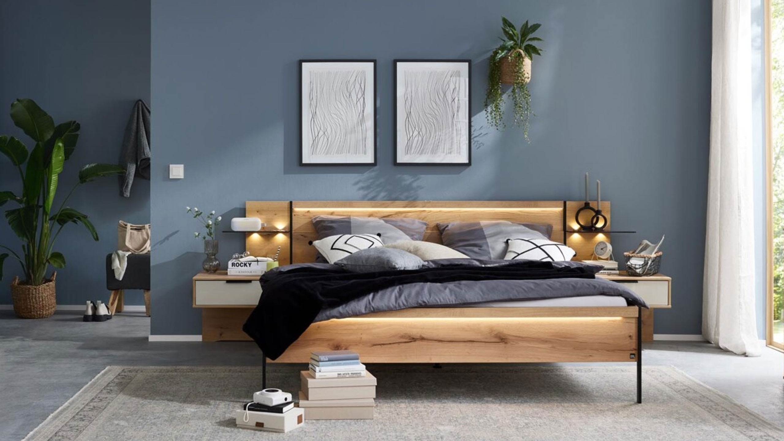 interliving holzbett im 1034 schlafzimmer vor einer blauen wand