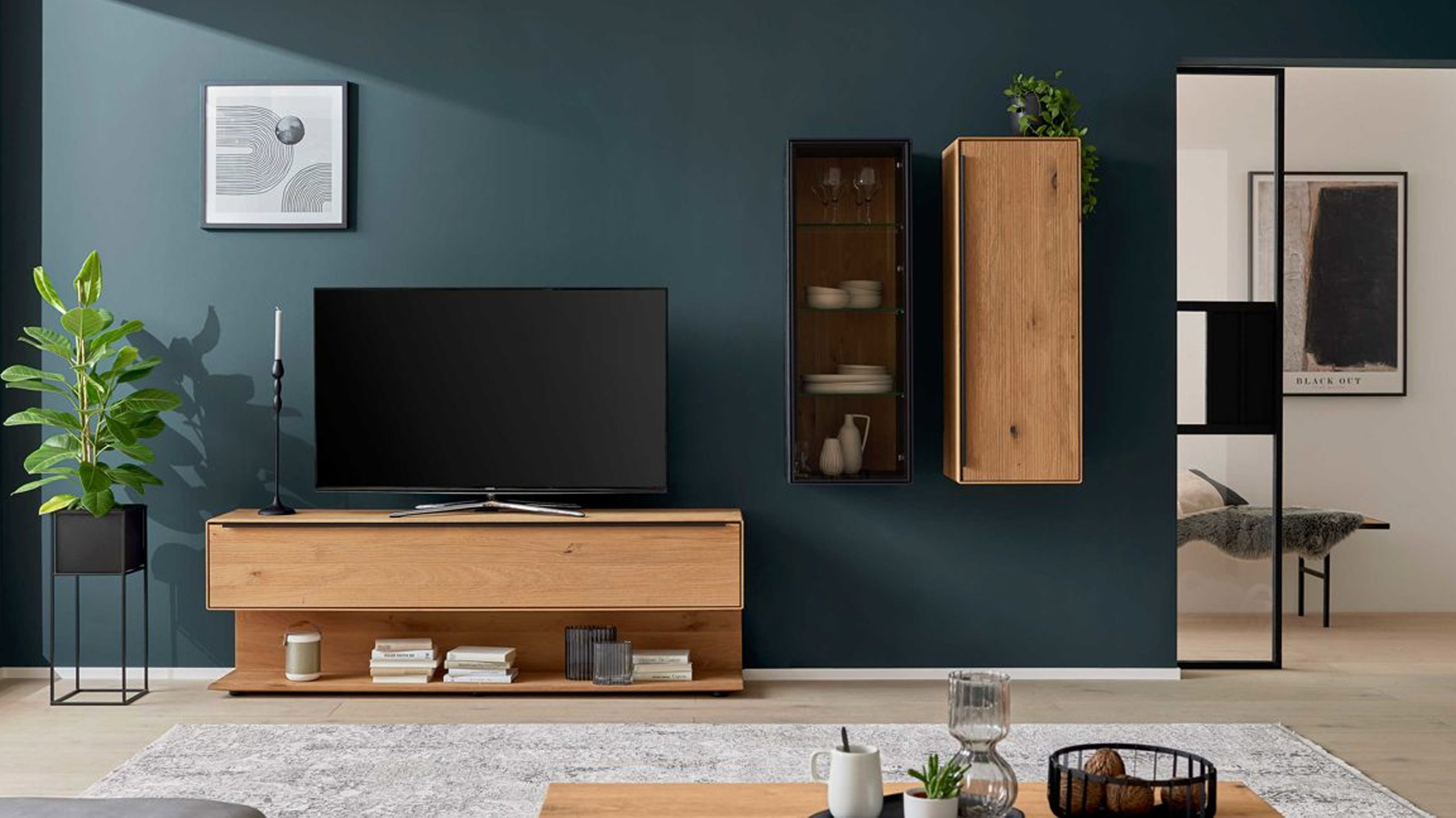 interliving 2033 holz wohnwand vor einer blaugrünen wand im wohnzimmer