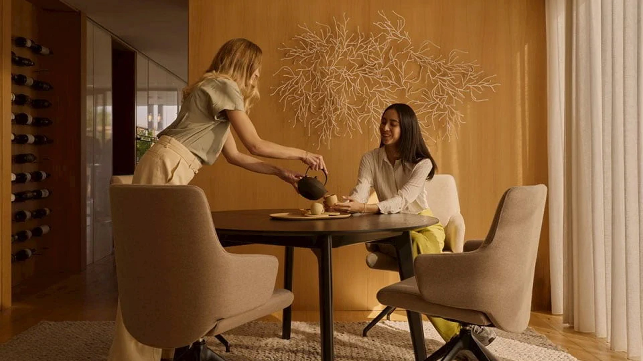 zwei frauen beim tee trinken in einem braunen esszimmer von stressless