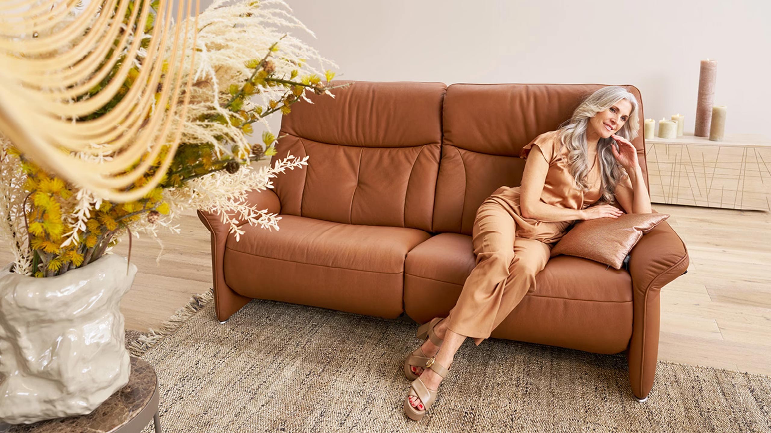 frau sitzt auf einem gemütlichen himolla cumuly sofa aus leder