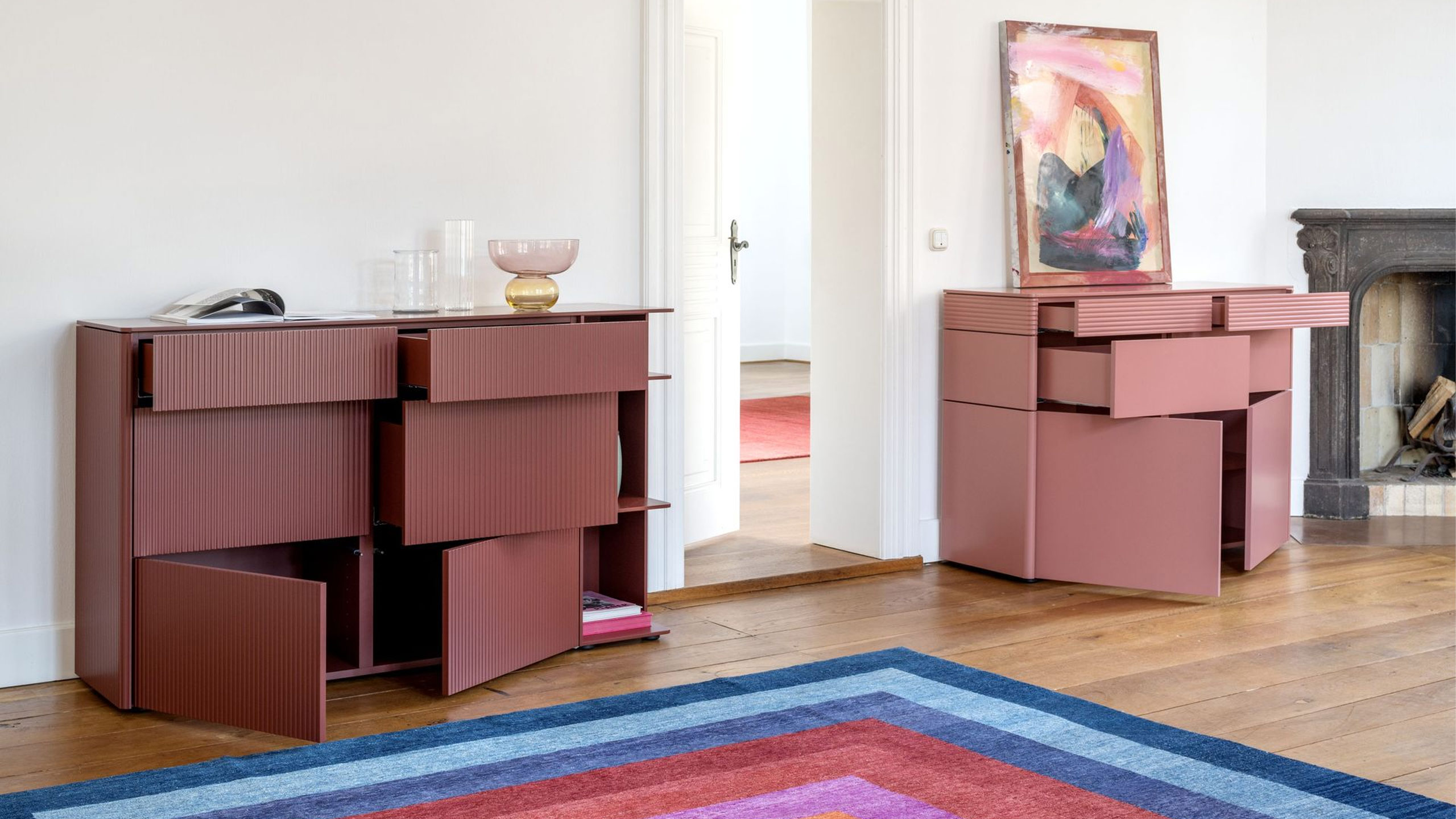 buntes sideboard sudbrock goya mit geöffneten schubladen und türen in einem klassischen minimalismus wohnzimmer mit eckkamin