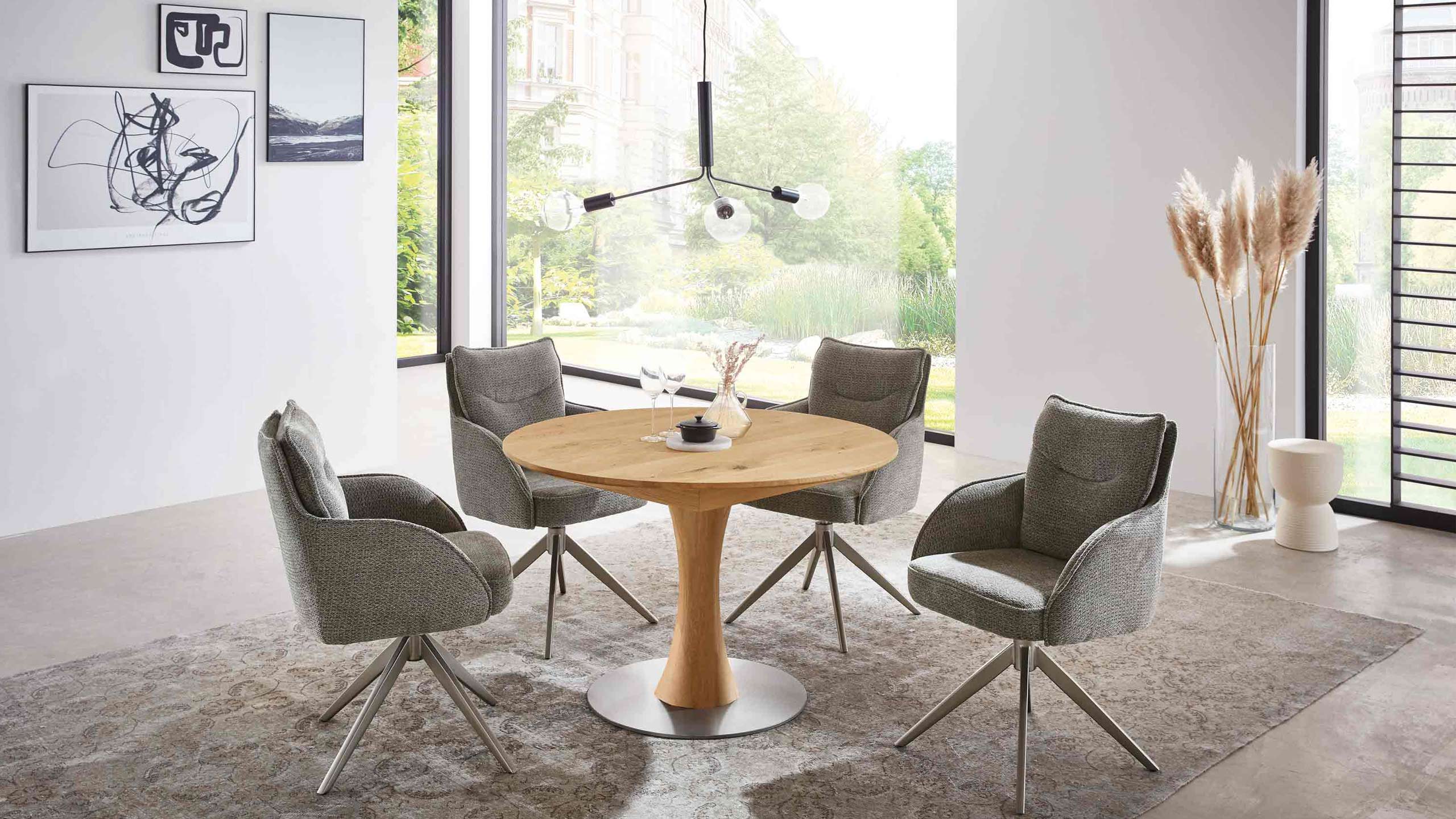 wöstmann rondo esstisch aus holz in rund mit stühlen in einem modernen wohnzimmer