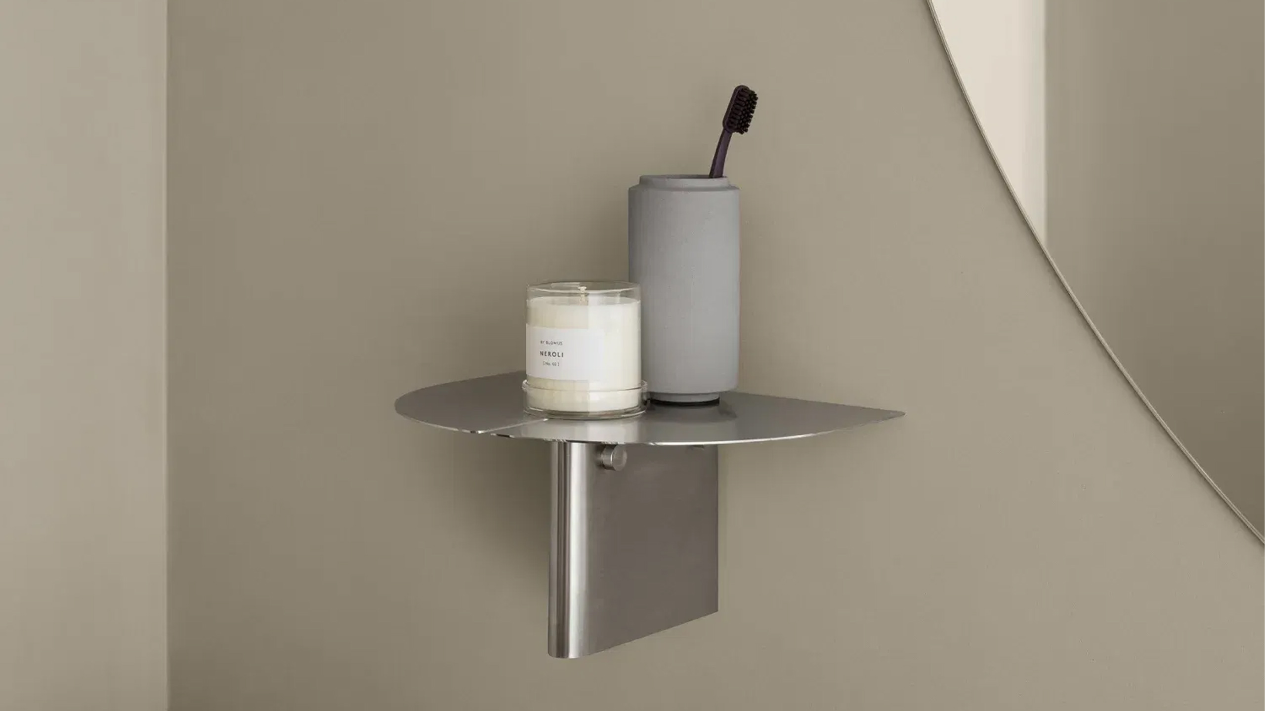 blomus oru wandregal aus edelstahl mit kerze und zahnbürste im becher drauf