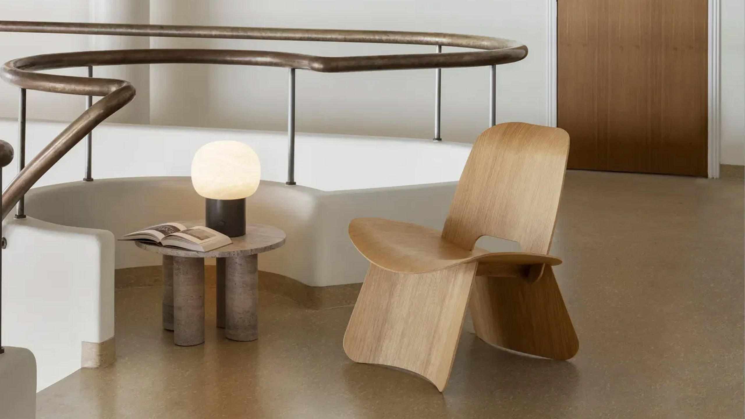 blomus volos beistelltisch aus travertin neben einem holz sessel