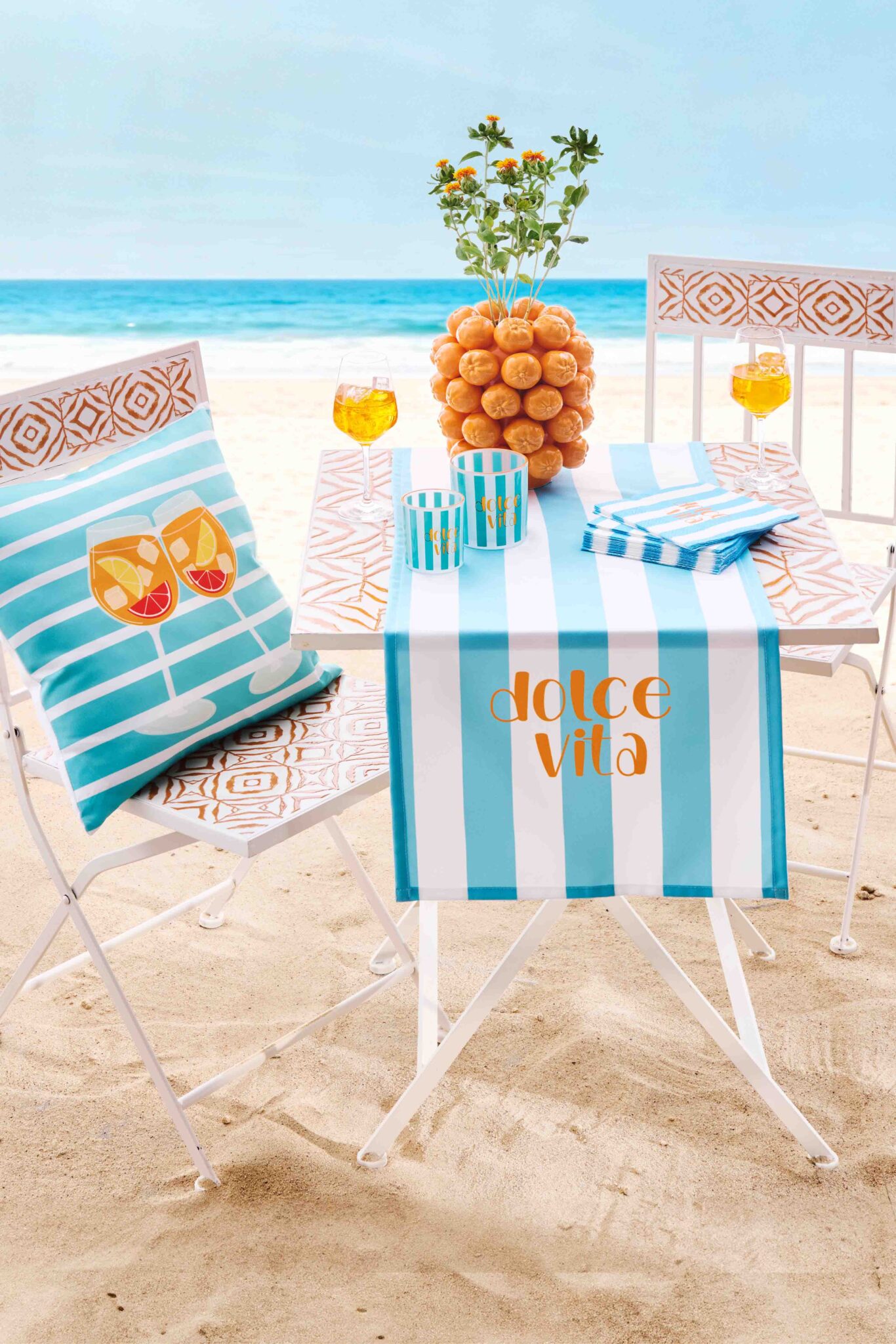 Strandbild mit Tisch und Stuhl, Decke und Kissen