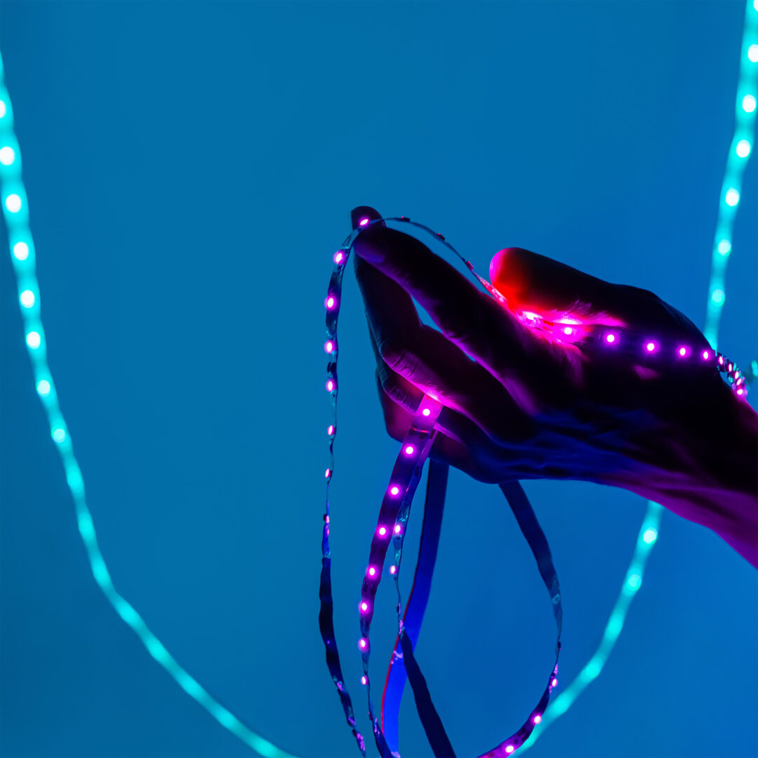 eine Hand hält bunte LED-Streifen