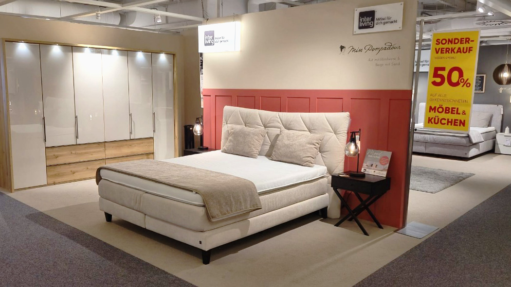 beiges Bett mit 50% Schild im Hintergrund